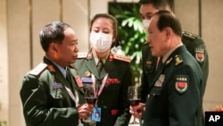 China Defense Minister Wei Fenghe, right, speaks with Laos's Gen. Chanthong Soneta-ath during the 19th International Institute for Strategic Studies Shangri-la Dialogue, in Singapore, June 11, 2022.