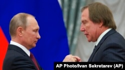 블라디미르 푸틴(왼쪽) 러시아 대통령이 지난 2016년 첼리스트 세르게이 롤두긴에게 훈장을 수여하고 있다. (자료사진)