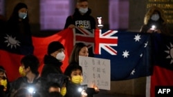 People hold placards and candles during a protest rally on the 33rd anniversary of the 1989 Tiananmen Square pro-democracy protests and crackdown, in Melbourne on June 4, 2022.