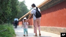 一位妈妈带着她的孩子在北京一处公园玩耍。（2021年5月20日）
