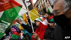 FILE - Demonstrators wave Western Sahara flags during a protest against the Spanish government support for Morocco's autonomy plan for Western Sahara, in Madrid, on March 26, 2022. 