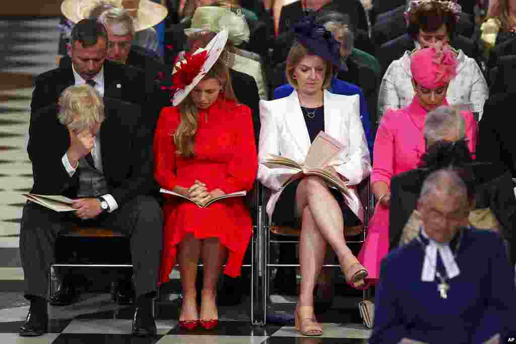 British Prime Minister Boris Johnson, right, reacts as he sits next to his wife, Carrie Johnson, at the National Service of Thanksgiving held at St Paul&#39;s Cathedral as part of celebrations marking the Platinum Jubilee of Britain&#39;s Queen Elizabeth II, in London.