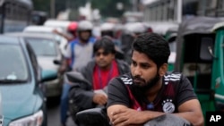 People wait in a long queues to buy fuel for their vehicles at a filling station in Colombo, Sri Lanka, June 11, 2022.