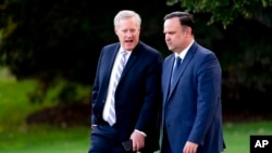 FILE - White House social media director Dan Scavino, right, and White House chief of staff Mark Meadows, walk on the South Lawn of the White House, Sept. 22, 2020, in Washington.