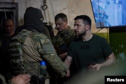 El presidente de Ucrania, Volodymyr Zelensky, premia a un soldado mientras visita una posición de miembros del servicio ucraniano, mientras continúa el ataque de Rusia contra Ucrania, en Lysychansk, región de Lugansk, Ucrania, el 5 de junio de 2022. Fotografía tomada el 5 de junio de 2022.