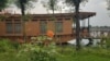 Flowers adorn a lawn area adjacent to a houseboat anchored on the banks of Kashmir's Nigeen Lake. (Bilal Hussain/VOA)