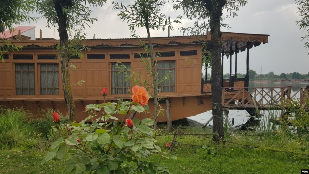 Flowers adorn a lawn area adjacent to a houseboat anchored on the banks of Kashmir's Nigeen Lake. (Bilal Hussain/VOA)