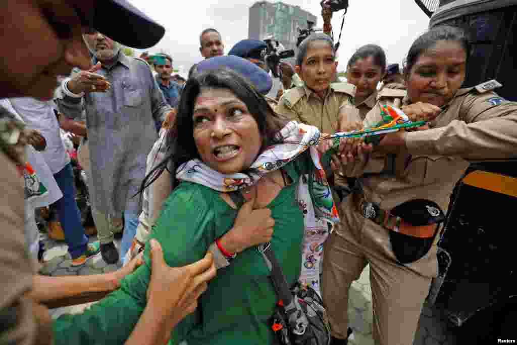 A supporter of India&#39;s main opposition Congress Party reacts as she is detained by police during a protest after the party leader Rahul Gandhi was summoned by the Enforcement Directorate in a money laundering case, in Ahmedabad. (REUTERS/Amit Dave)