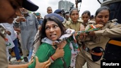 A supporter of India&#39;s main opposition Congress party&nbsp; reacts as she is detained by police during a protest after the party leader Rahul Gandhi was summoned by the Enforcement Directorate in a money laundering case, in Ahmedabad.