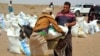 FILE - Poor Yemeni families receive flour rations and other basic food supplies from charities in the province of Lahj, in southern Yemen, March 29, 2022. The fact that Ukraine supplies nearly a third of Yemen's wheat imports has heightened fears of a deepening famine.