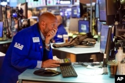 Traders work on the floor at the New York Stock Exchange in New York, Tuesday, June 14, 2022. Wall Street is switching between gains and losses Tuesday in its first trading after tumbling into a bear market. (AP Photo/Seth Wenig)