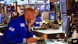 Traders work on the floor at the New York Stock Exchange in New York, Tuesday, June 14, 2022. Wall Street is wobbling between gains and losses Tuesday in its first trading after tumbling into a bear market on worries about a fragile economy and rising rat