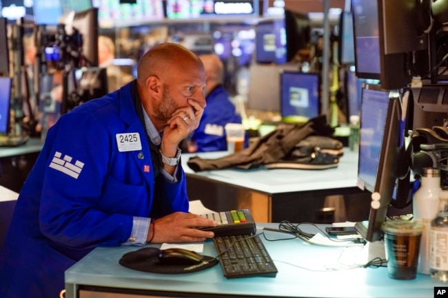 Traders work on the floor at the New York Stock Exchange in New York, Tuesday, June 14, 2022. Wall Street is switching between gains and losses Tuesday in its first trading after tumbling into a bear market. (AP Photo/Seth Wenig)