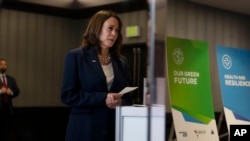 Vice President Kamala Harris is reflected in the mirror as she listens to Aida Saucedo from Mexico's National Women's Civic Association while touring an exhibit hall at the Summit of the Americas in Los Angeles, June 6, 2022.