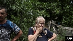 Yevgeniya Panicheva reacts as she stands in the yard of a house where two people were killed during shelling in the city of Lysychansk in the eastern Ukrainian region of Donbas on June 13, 2022, amid Russian invasion of Ukraine. - The cities of Severodone