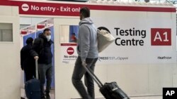 Archivo - Un pasajero sale de un módulo de pruebas de COVID-19 en el aeropuerto de Heathrow en Londres, el 29 de noviembre de 2021. (AP Foto/Frank Augstein, Archivo)