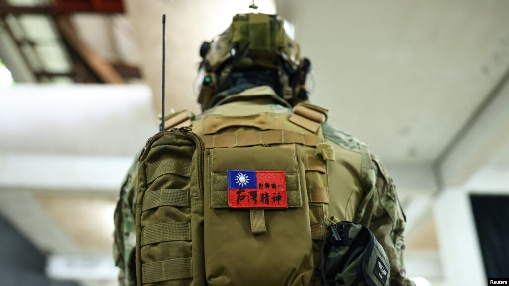 台湾新台北市一名市民背着写有“世界第一，台湾精神”的台湾旗帜的背包参加使用仿真枪的枪击和战斗技能训练。（2022年5月21日）(photo:VOA)