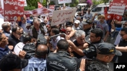 Des manifestants bloqués par la police alors qu'ils se dirigeaient vers le siège de l'autorité électorale ISIE, lors d'un rassemblement contre leur président, à Tunis, le 4 juin 2022.