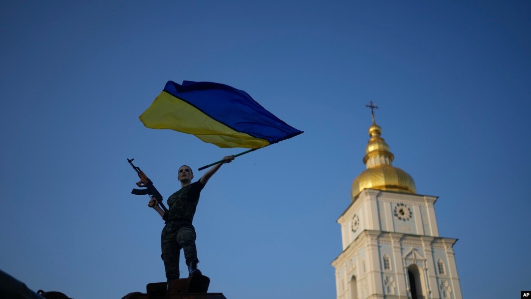 Женщина с украинским флагом на башне поверженного российского танка в Киеве, Украина. 10 июня 2022 г.