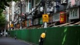 FILE - A man looks in through a gap in a barrier in a residential area, after the lockdown placed to curb the coronavirus disease (COVID-19) outbreak was lifted in Shanghai, China June 7, 2022. 