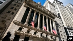 FILE - A pedestrian walks past the New York Stock Exchange, Jan. 24, 2022, in New York.