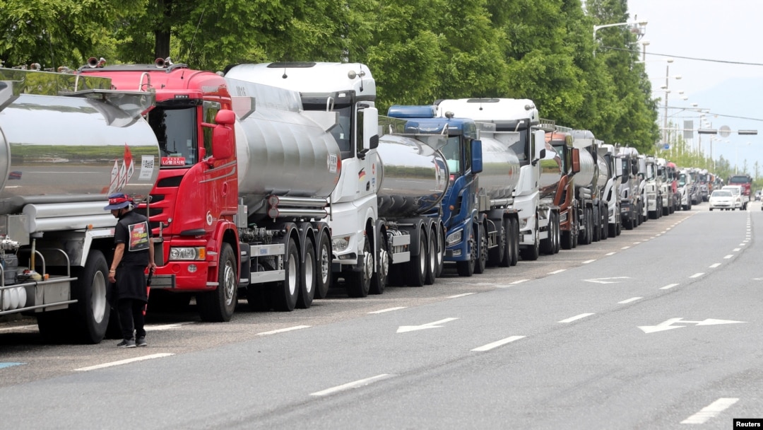 Anggota serikat Solidaritas Pengemudi Truk Kargo berdiri di samping truk saat mogok kerja di Yeosu, Korea Selatan, 9 Juni 2022. (Foto: via Reuters)