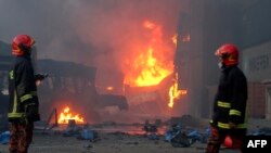 Petugas pemadam kebakaran tiba di lokasi setelah kebakaran terjadi di fasilitas penyimpanan peti kemas di Sitakunda, sekitar 40 km dari pelabuhan utama Chittagong pada 5 Juni 2022. (Foto: AFP)