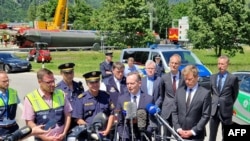 German Minister for Transport and Digital Affairs Volker Wissing (2ndR) speaks to the media near the site of a train derailment near Burgrain, north of Garmisch-Partenkirchen, southern Germany, on June 4, 2022, a day after the accident.