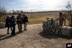 FILE - Journalists take pictures of a soldier during a press tour near the front line in Brovary, on the outskirts of Kyiv, Ukraine, March 28, 2022.