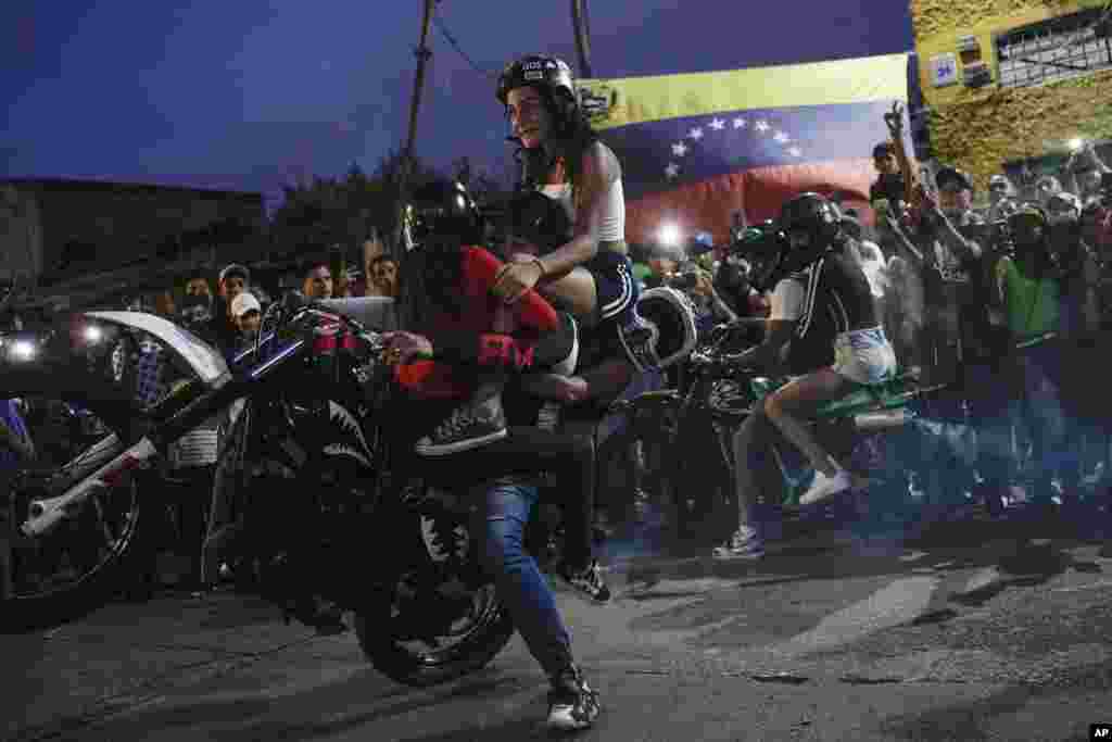 A motorcyclist performs a wheelie on his motorbike during an exhibition in the Chapellin neighborhood of Caracas, Venezuela, June 12, 2022. 