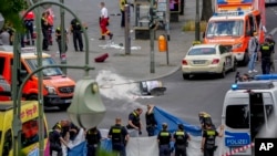 Police officers cover a dead body after a car crashed into a crowd of people in central Berlin, Germany, June 8, 2022.