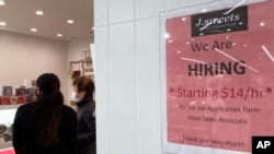 Un cartel de contratación se muestra en una tienda de postres en Arlington Heights, Illinois, el 27 de diciembre de 2022.