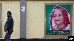 
Seorang pria berjalan melewati potret Perdana Menteri Bangladesh Sheikh Hasina pada malam sebelum pemilu di Dhaka, Bangladesh, Sabtu, 29 Desember 2018.
