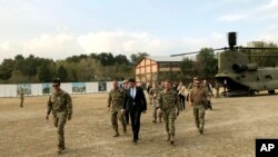 U.S. Defense Secretary Mark Esper, center, walks Gen. Scott Miller, right, chief of the U.S.-led coalition in Afghanistan, at the U.S. military headquarters in Kabul, Oct. 20, 2019. 