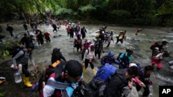 ARCHIVO - Migrantes cruzan un río en el Tapón del Darién desde Colombia hacia Panamá, con la esperanza de llegar a EEUU. El 15 de octubre de 2022.