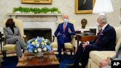 President Joe Biden accompanied by Vice President Kamala Harris speaks during a meeting with lawmakers on investments in infrastructure, in the Oval Office of the White House, Feb. 11, 2021. Sen. Tom Carper, D-Del., listens at right. 