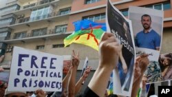 A man holds a portrait of activist Nasser Zefzafi, who was sentenced to 20 years in prison on June 26, 2018, as people take part in a demonstration demanding the liberation of activists, prompted by the death of a fish vendor, in Casablanca, Morocco, Oct. 8, 2017.