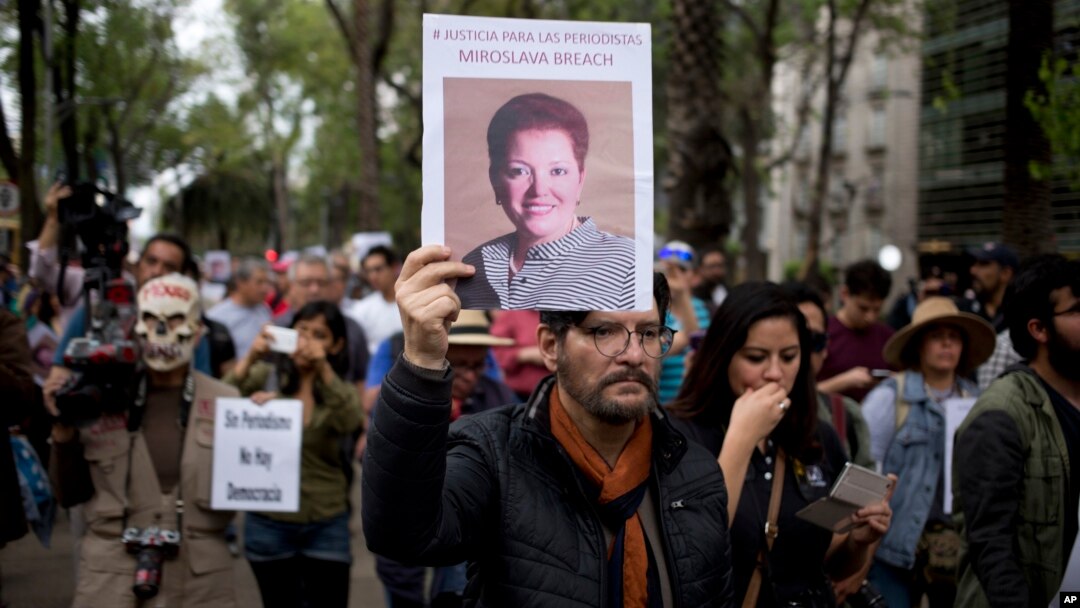 A man holds up a photo of Mexican journalist Miroslava Breach, gunned down in the northern state of Chihuahua on Thursday, during a march in Mexico City, March 25, 2017.