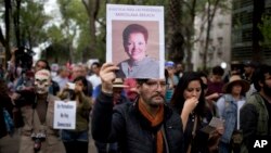 A man holds up a photo of Mexican journalist Miroslava Breach, gunned down in the northern state of Chihuahua on Thursday, during a march in Mexico City, March 25, 2017.