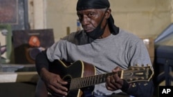 Bluesman Jimmy "Duck" Holmes plays a quick ditty at the Blue Front Cafe in Bentonia, Miss., Jan. 21, 2021. Holmes' ninth album, "Cypress Grove," has earned a Grammy nomination for the Best Traditional Blues Album. (AP Photo/Rogelio V. Solis)