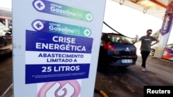Pengemudi dijatah/dibatasi dalam mengisi bahan bakar di sebuah pompa bensin di Lisabon, Portugal, Senin (12/8).