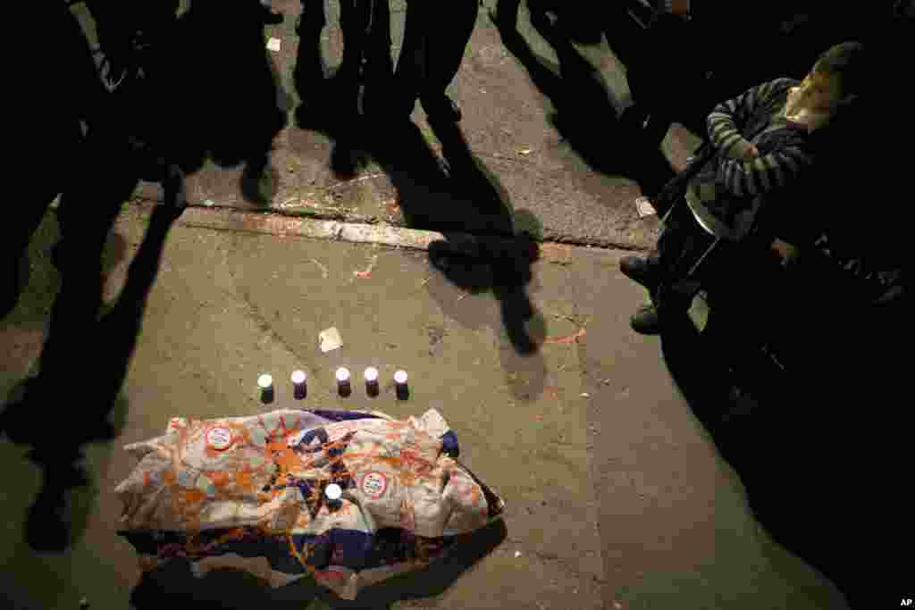 Israeli right wing activists stand around a makeshift coffin and symbolized burial during a demonstration at the site where a Palestinian man rammed a minivan into a crowded train stop, in Jerusalem, Nov. 5, 2014. 