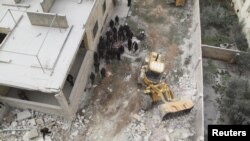 Civil defense workers remove dead bodies from under debris after an airstrike on Kafr Hamra village in the northern Aleppo countryside of Syria, Feb. 27, 2016.