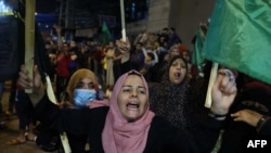 Des femmes égyptiennes célèbrent dans les rues après un cessez-le-feu négocié par l'Égypte entre Israël et le mouvement islamiste au pouvoir Hamas, à Rafah, dans le sud de la bande de Gaza, le 21 mai 2021. (Photo de SAID KHATIB / AFP)