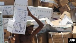 FILE - A Yemeni man unloads medical aid boxes from a boat carrying 460 tonnes of Emirati relief aid that docked in the port of the city of Aden, May 24, 2015.