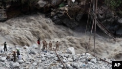 Indijski vojnici i dobrovoljci pokušavaju da spasu hodočasnike od nabujale reke