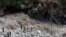 Water gushes down a river as Indian paramilitary soldiers and volunteers stand near a makeshift bridge after it was damaged hampering to evacuate the stranded pilgrims in Govindghat, India, June 22, 2013. 