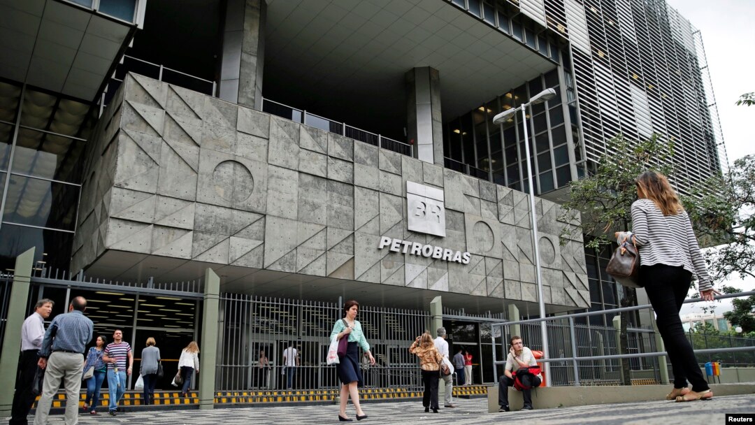 FILE - People walk in front of Brazilian oil company Petrobras's headquarters in Rio de Janeiro, Nov. 14, 2014.