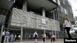 FILE - People walk in front of Brazilian oil company Petrobras's headquarters in Rio de Janeiro, Nov. 14, 2014.