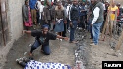 FILE - A woman cries over the body of man who was killed by police, witnesses said, in Mathare slum in Nairobi, Kenya, Aug. 9, 2017.